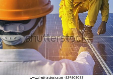 Two engineer or installer inspecting solar energy panels.