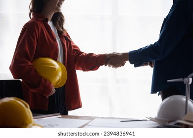 Two engineer shaking hands in congratulations office.