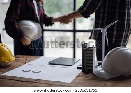 Two engineer shaking hands in congratulations office.