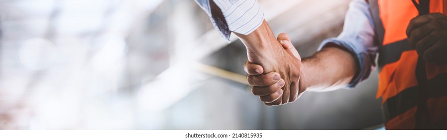 Two engineer shaking hands with deals and congratulations on success, panorama image use for cover design.