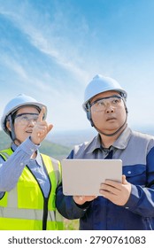 Two Engineering Workers Checking Data on Outdoor Worksite