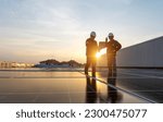Two engineers checking solar panel installation on roof of house and home office at sunset Energy-efficient and cost-saving ideas for small business owners.