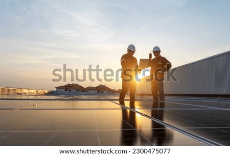 Two engineers checking solar panel installation on roof of house and home office at sunset Energy-efficient and cost-saving ideas for small business owners.