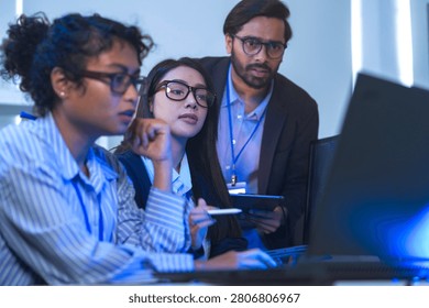 Two engineers seen from behind studying source code on large monitors facing a wall of monitors filled with source code. The close-up captures modern software development, modernoffice.