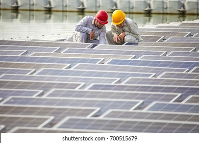 Two engineers squatted on the patrol water floating solar photovoltaic