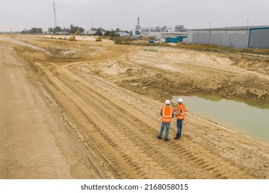 Two Engineers Starting The Building On En Empty Construction Site