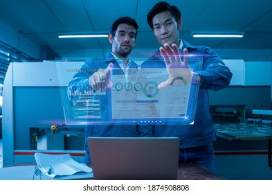 Two engineers use a digital tablet computer with Augmented Reality software to visualize the maintenance and diagnostics of the equipment in production planning in Smart Factory 4.0.