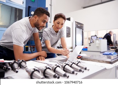 Two Engineers Using CAD Programming Software On Laptop