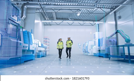 Two Engineers Walk Through Factory Workshop with Augmented Reality 3D Models CNC Machinery Production Line. Industry 4.0 Graphics Visualization in Factory. VFX Special Graphic Effects - Powered by Shutterstock