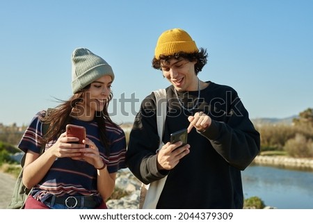 Two engrossed young people talking while chatting along a beach