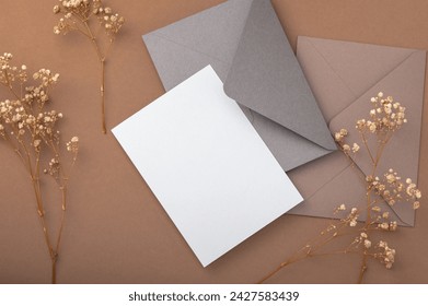 Two envelopes and a blank card on a beige background and dried gypsophila flowers. Warm earthy tones. Postcard. - Powered by Shutterstock - Get 15% off with code: PIKWIZARD15