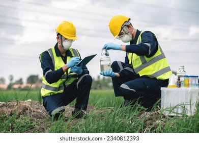 Two Environmental Engineers Inspect Water Quality and Take Water Samples Notes in The Field Near Farmland, Natural Water Sources maybe Contaminated by Toxic Waste or Suspicious Pollution Sites. - Powered by Shutterstock