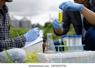 Two Environmental Engineers Inspect Water Quality and Take Water sample notes in The Field Near Farmland, Natural Water Sources maybe Contaminated by Toxic Waste or Suspicious Pollution Sites. - Shutterstock ID 2394555741