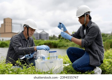 Two Environmental Engineers Inspect Water Quality and Take Water sample notes in The Field Near Farmland, Natural Water Sources maybe Contaminated by Toxic Waste or Suspicious Pollution Sites. - Shutterstock ID 2394555747
