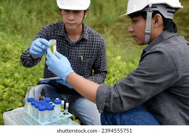 Two Environmental Engineers Inspect Water Quality and Take Water sample notes in The Field Near Farmland, Natural Water Sources maybe Contaminated by Toxic Waste or Suspicious Pollution Sites. - Shutterstock ID 2394555751