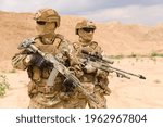 Two equipped and armed special forces soldiers with rifles in the desert