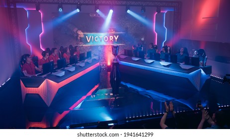 Two Esport Teams of Pro Gamers Play in RPG Strategy Video Game on a Championship Arena, Team Wins Round and Celebrates with High-Fives.Big Screen Showing Victory Sign. Cyber Games Tournament Event - Shutterstock ID 1941641299