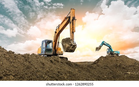 Two excavators work on construction site at sunset - Shutterstock ID 1262890255