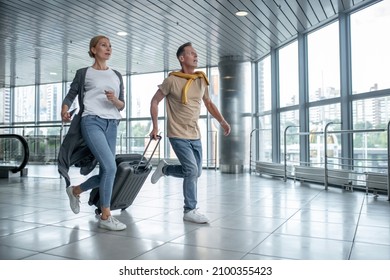 Two excited tourists hurrying to catch the flight