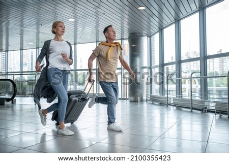 Two excited tourists hurrying to catch the flight