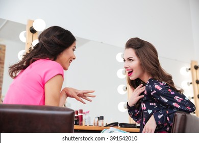 Two Excited Wondered Young Women Talking Near The Mirror In Beauty Salon