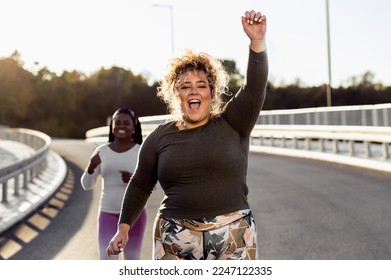 Two excited young plus size women jogging together. - Powered by Shutterstock