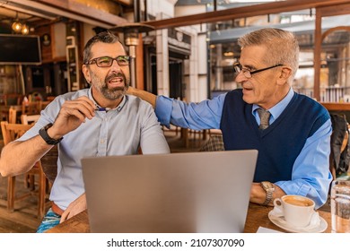 Two experienced businessmen are having a discussion about their new ideas and plans in the café - Powered by Shutterstock