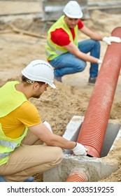 Two Experienced Workers Installing A Residential Sewer Line