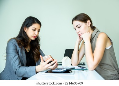 Two Expertise Business Women In Well Dressed Are Checking The Selling And Interest About The Property On Internet By Using Electronic Device In The Office Background. Business Concept With Copy Space.