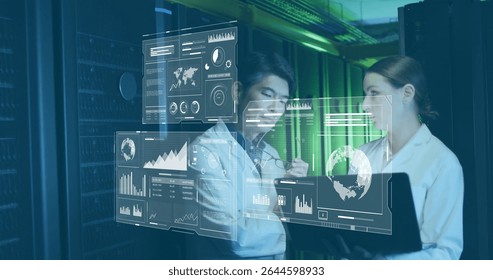 Two IT experts analyzing floating data holograms in server room corridor, with laptop and stylus. Technology, innovation, data visualization, cybersecurity, digital, futuristic, collaboration