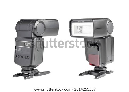 Two external camera flash speedlights isolated on a clean white background. Front and side view of professional photographic electronic flash units with stands.