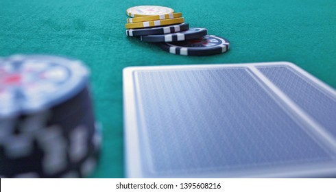 Two face-down pocket cards with chips on a green poker gaming table