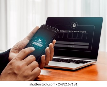 Two factor authentication or 2FA, cyber security concept. Password numbers with key icon for verification code on mobile smartphone screen holding by businessman hand who working with laptop computer.