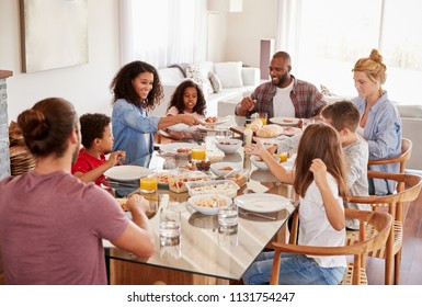 Two Families Enjoying Meal At Home Together