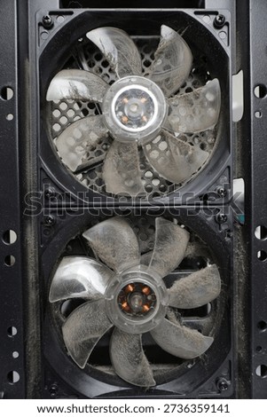 Two fans, covered with a thick layer of dust, on the back wall of the system unit. The computer's cooling system is dirty.                            