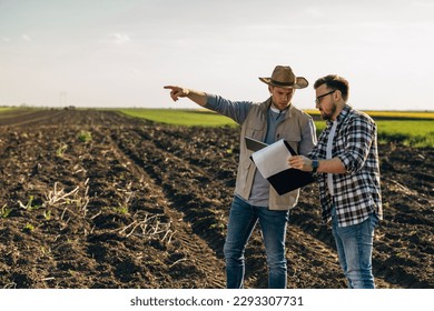 Two farmers are checking the analysis on digital tablet