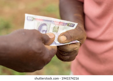 Two Farmers (man And Woman) Exchanging Money In Kenyan Shilling Currency