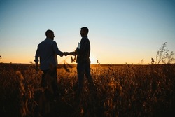 Two Farmers Shaking Hands In Soybean Field