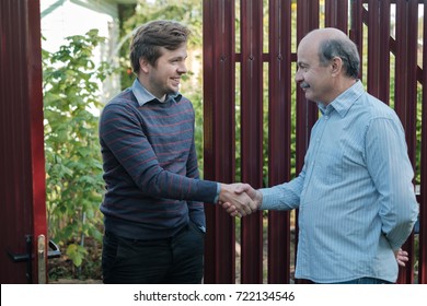 two farmers shaking hands and talking to each other on sunny day - Powered by Shutterstock