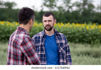 Two Farmers Standing In Oat Field And Talking