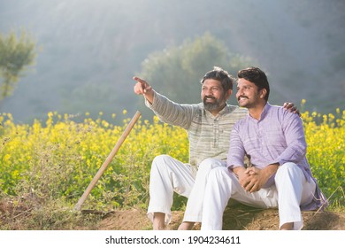 Two Farmers Talking On Agricultural Field