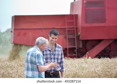 Two Farmers Talking On Wheat Field During Wheat Harvest