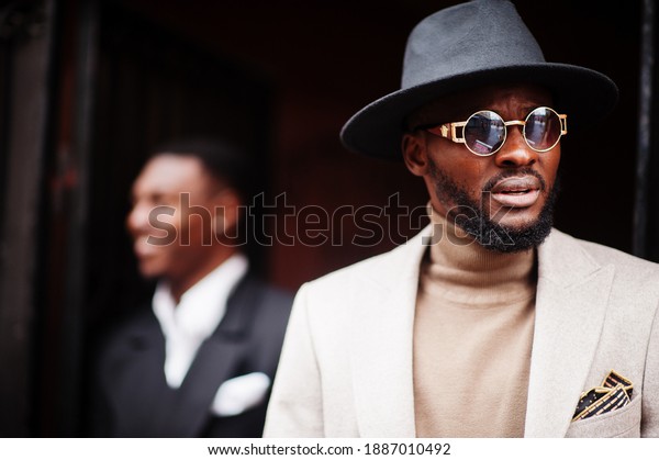 Two fashion black men.\
Fashionable portrait of african american male models. Wear suit,\
coat and hat.