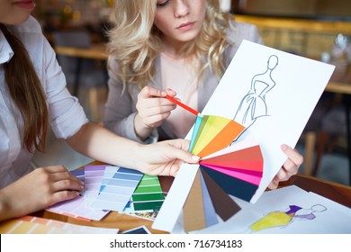 Two fashion designers choosing color for new model of dress from pantone chart - Powered by Shutterstock