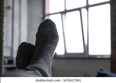 Two feet of a man who is lying on a bed, against the background of a window on a sunny day - Shutterstock ID 1476517541