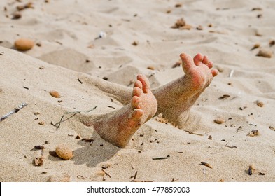 Two Feet On The Beach In Rigor Mortis Protrude From The Sand