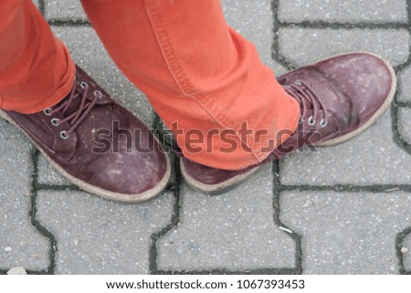 two feets on the ground, brown shoes