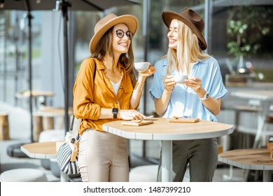 Two Female Best Friends Spending Time Together On The Cafe Terrace, Feeling Happy, Enjoying Coffee During A Summer Day