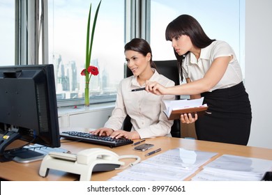 Two Female Business Women In Office Setting Working