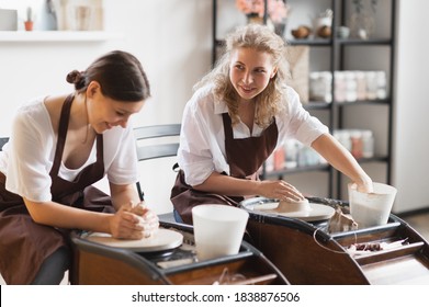 Two Female Ceramic Artists In Apron Using Clay Material Working In Potter Studio. Evening Freelance Distance Learning. Adult Hobby Adventure. Winter Educating Leisure. Training In Modern Workshop.